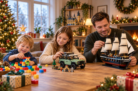 Gezin bouwt met LEGO® stenen, een terreinwagen en een zeilschip aan een tafel met cadeaus