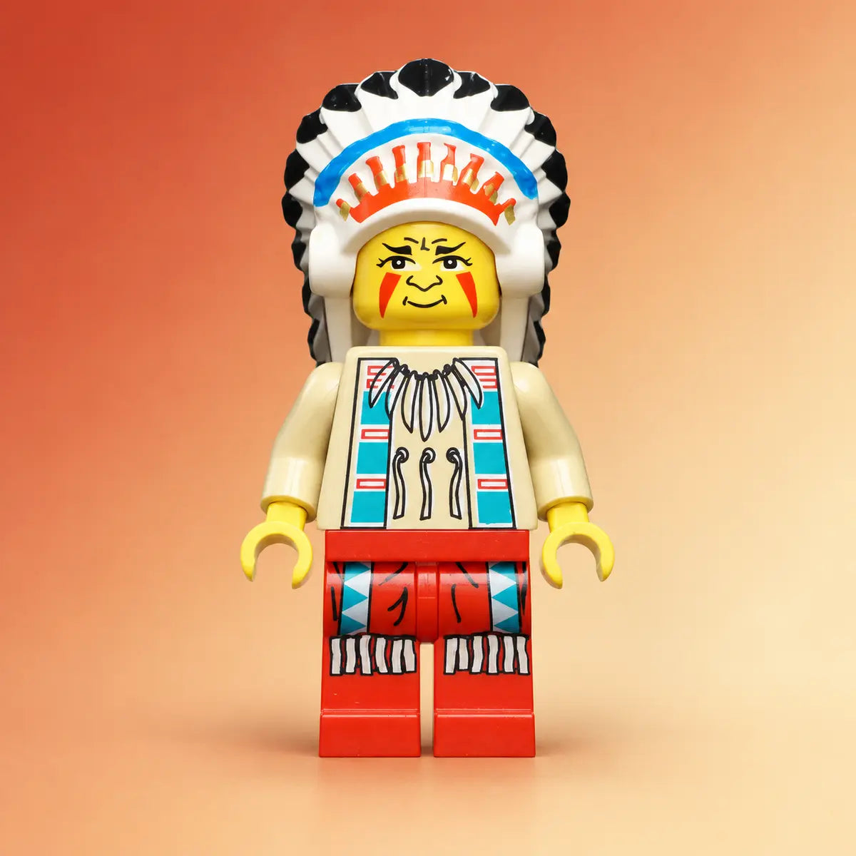 LEGO® Western minifiguur ww017 met hoofdtooi en rode broek op een zandkleurige achtergrond