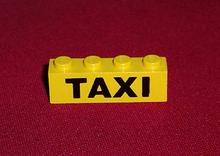 Part 3010p45 - Brick 1 x 4 with Black 'TAXI' Pattern - De BrickPlaats
