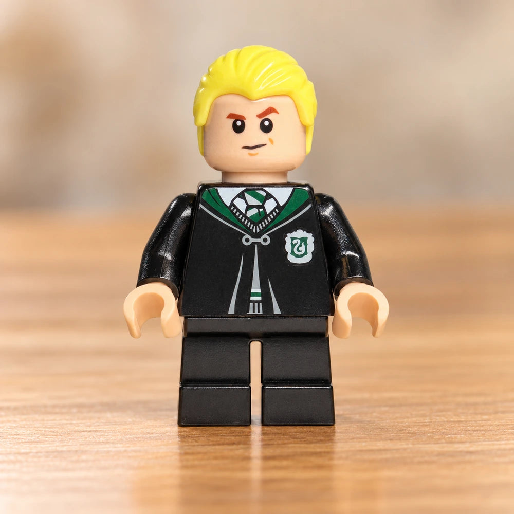LEGO® Harry Potter-minifiguur Draco Malfoy hp254 in zwart Zwadderich-gewaad op een houten tafel